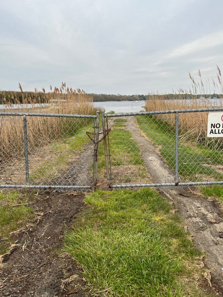 a fenced off area with a body of water in the background (MyCoast AI)