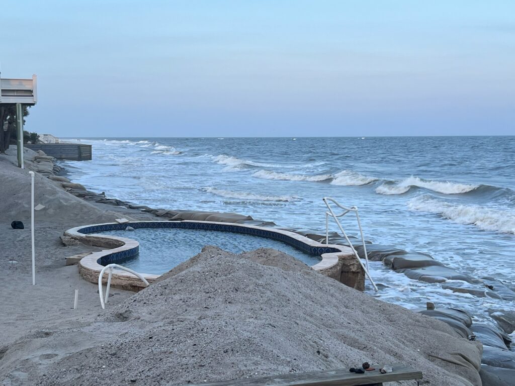 a beach with a pool and chairs (MyCoast AI)