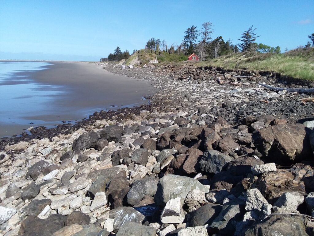 a rocky beach with a red house (MyCoast AI)