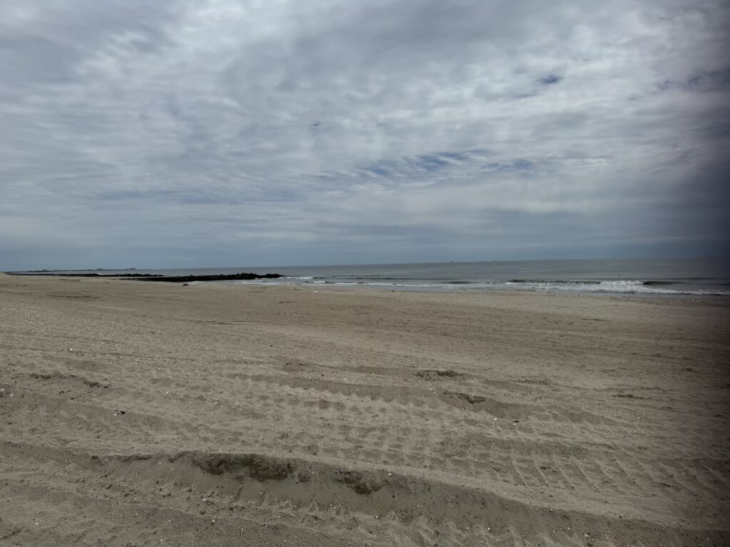 a sandy beach with waves crashing (MyCoast AI)
