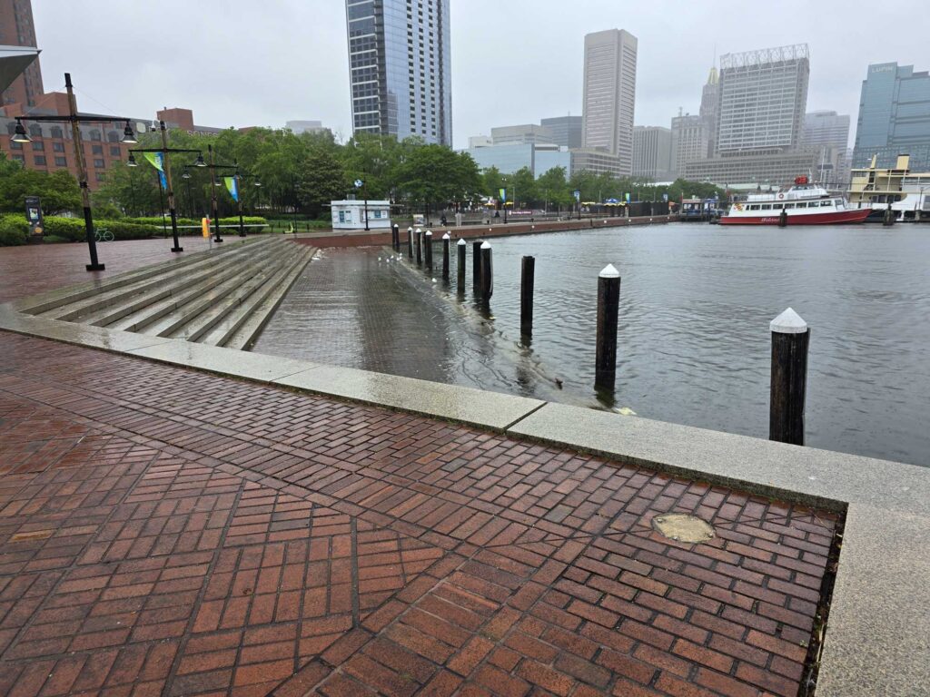 a brick walkway over water with boats in the background (MyCoast AI)