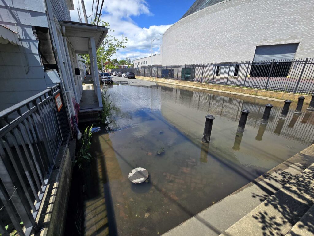 a flooded street with a car parked on the side (MyCoast AI)