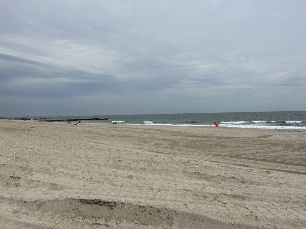 a beach with a red frisbee in the sand (MyCoast AI)