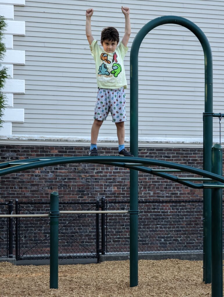 a child on a green metal railing (MyCoast AI)