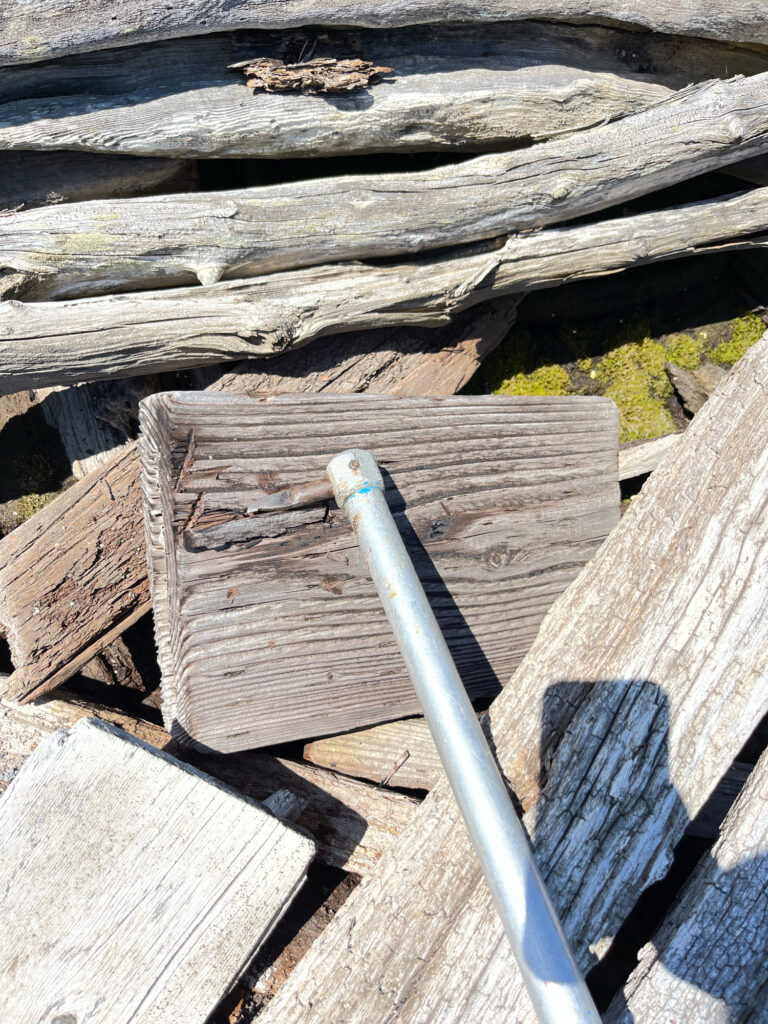 a wooden fence with a metal object on it (MyCoast AI)