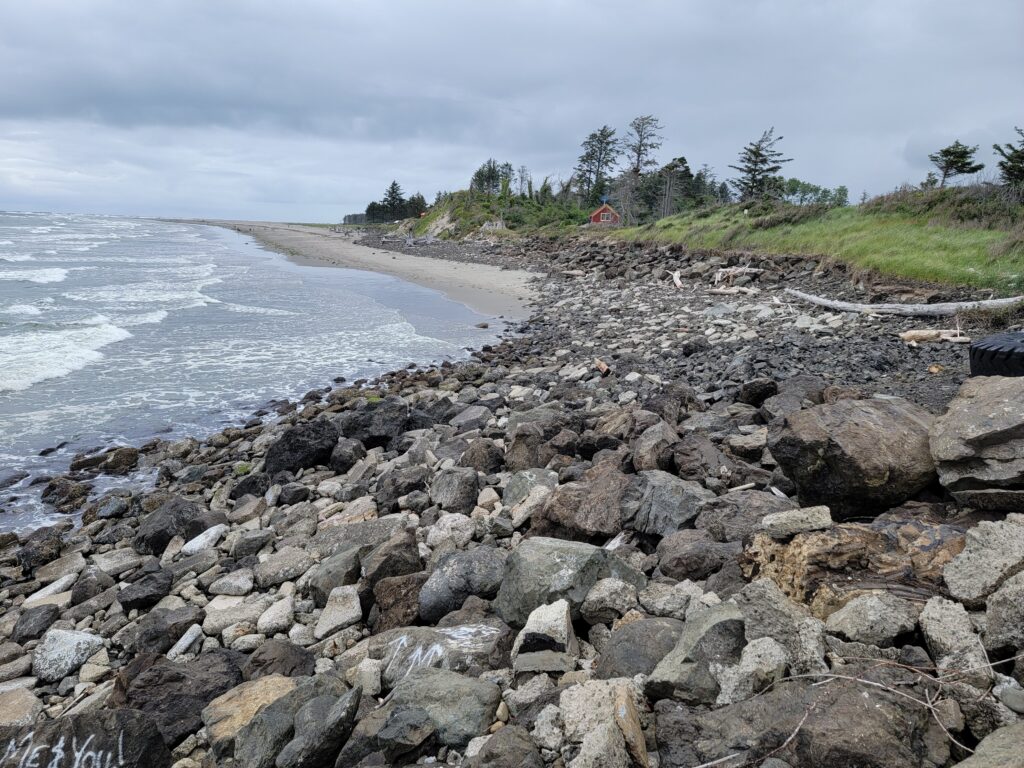 a rocky beach with a house in the distance (MyCoast AI)