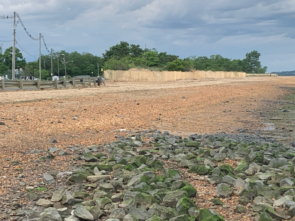 a rocky area with a fence and trees in the background (MyCoast AI)