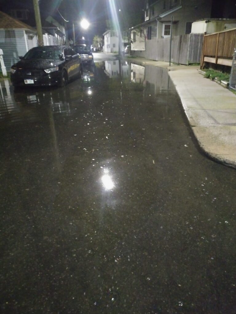 a wet street with cars parked on the side (MyCoast AI)
