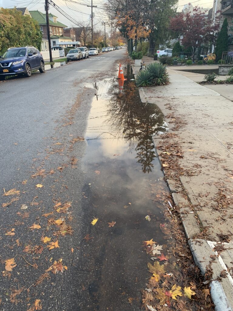 a wet street with cars parked on the side (MyCoast AI)