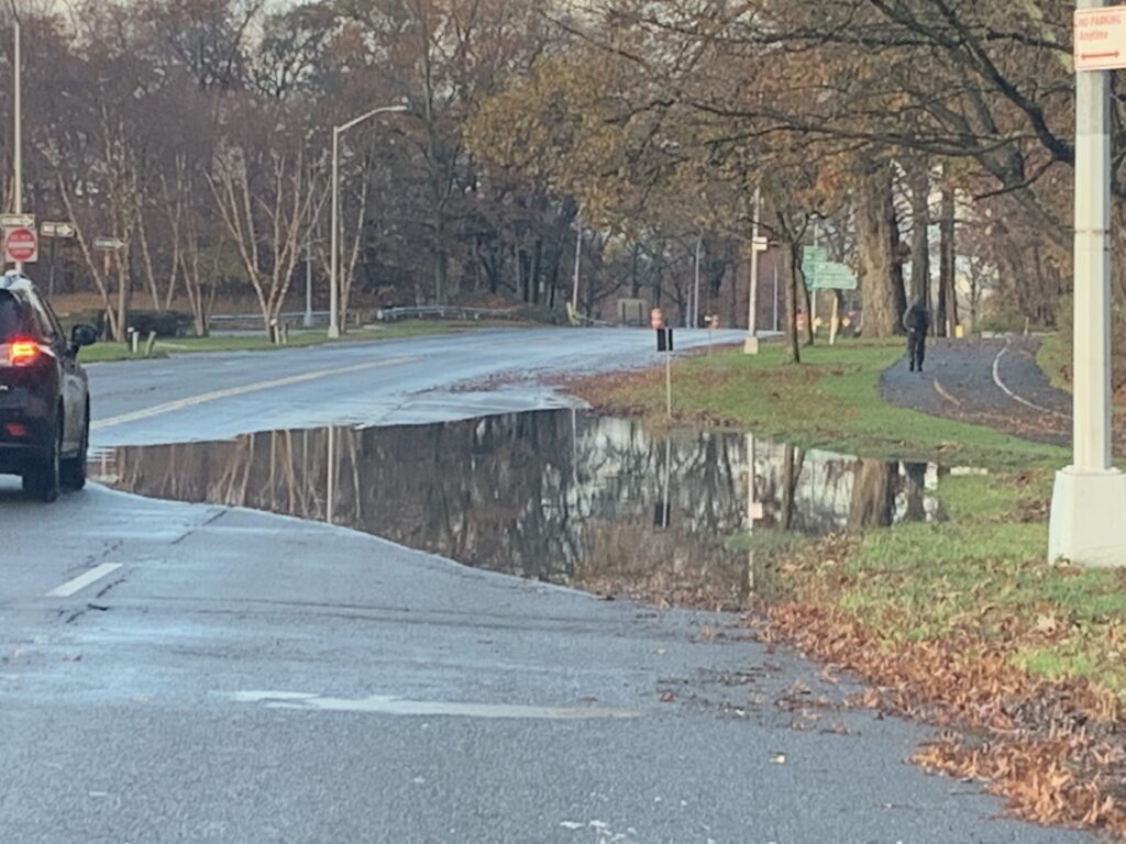 a flooded road with a car driving by (MyCoast AI)