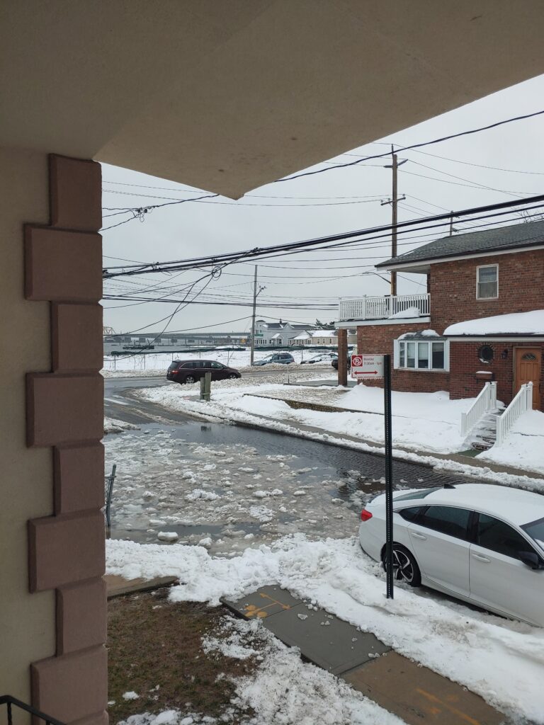 a snowy street with cars parked on the side (MyCoast AI)