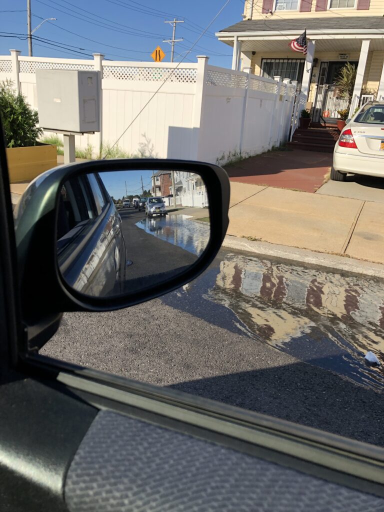 a car mirror showing a street (MyCoast AI)