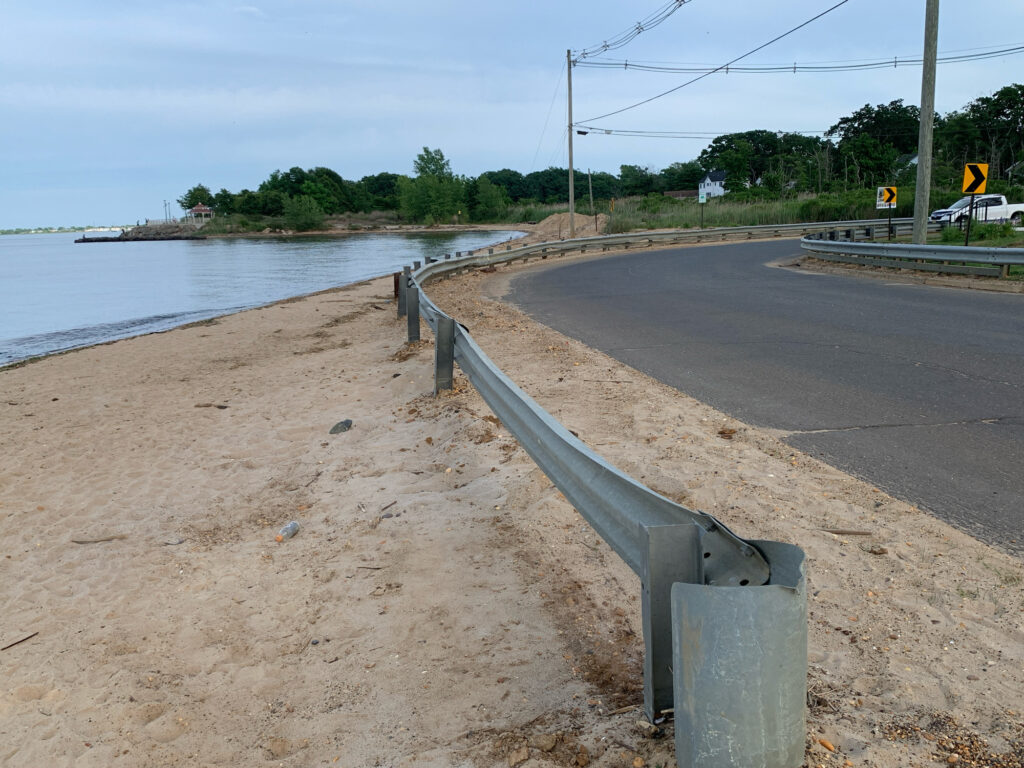 a road with a railing and water on the side (MyCoast AI)