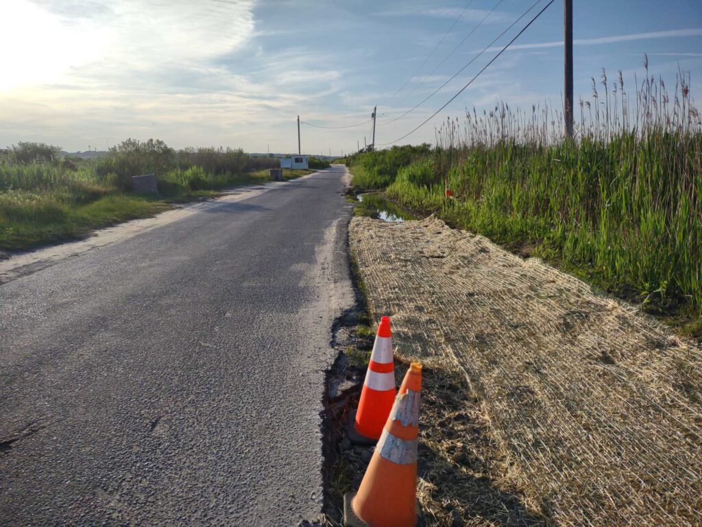 a road with orange cones on the side with Vietnam Veterans Memorial in the background (MyCoast AI)