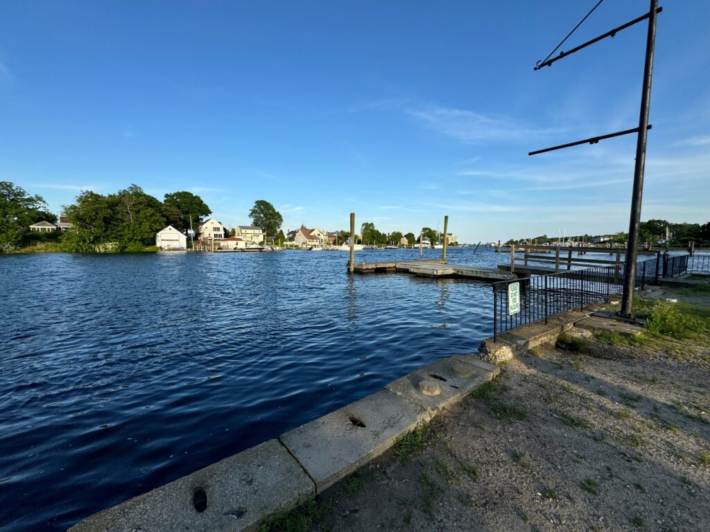 a body of water with a dock and buildings in the background (MyCoast AI)