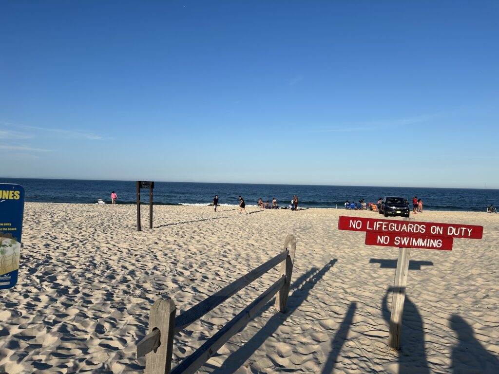 a beach with people and a sign (MyCoast AI)