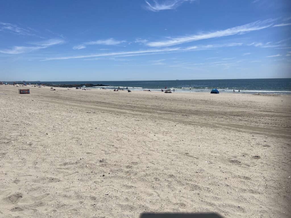 a sandy beach with boats in the water (MyCoast AI)