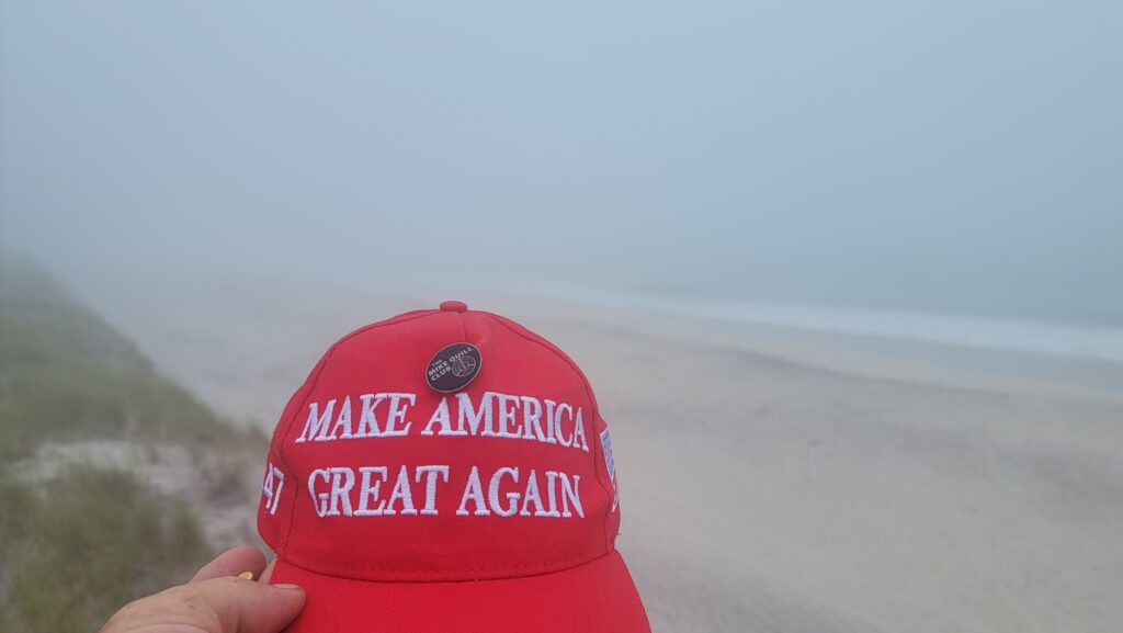 a hand holding a red plastic container with a white label on it (MyCoast AI)