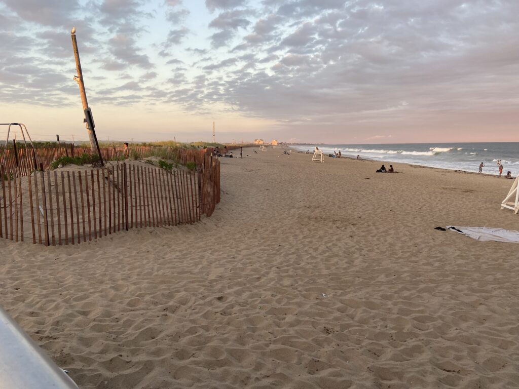a sandy beach with a fence and a wooden post (MyCoast AI)