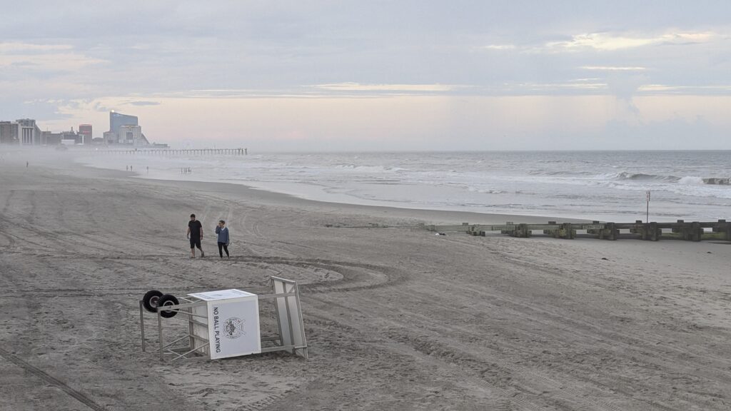 a couple of people walking on a beach (MyCoast AI)