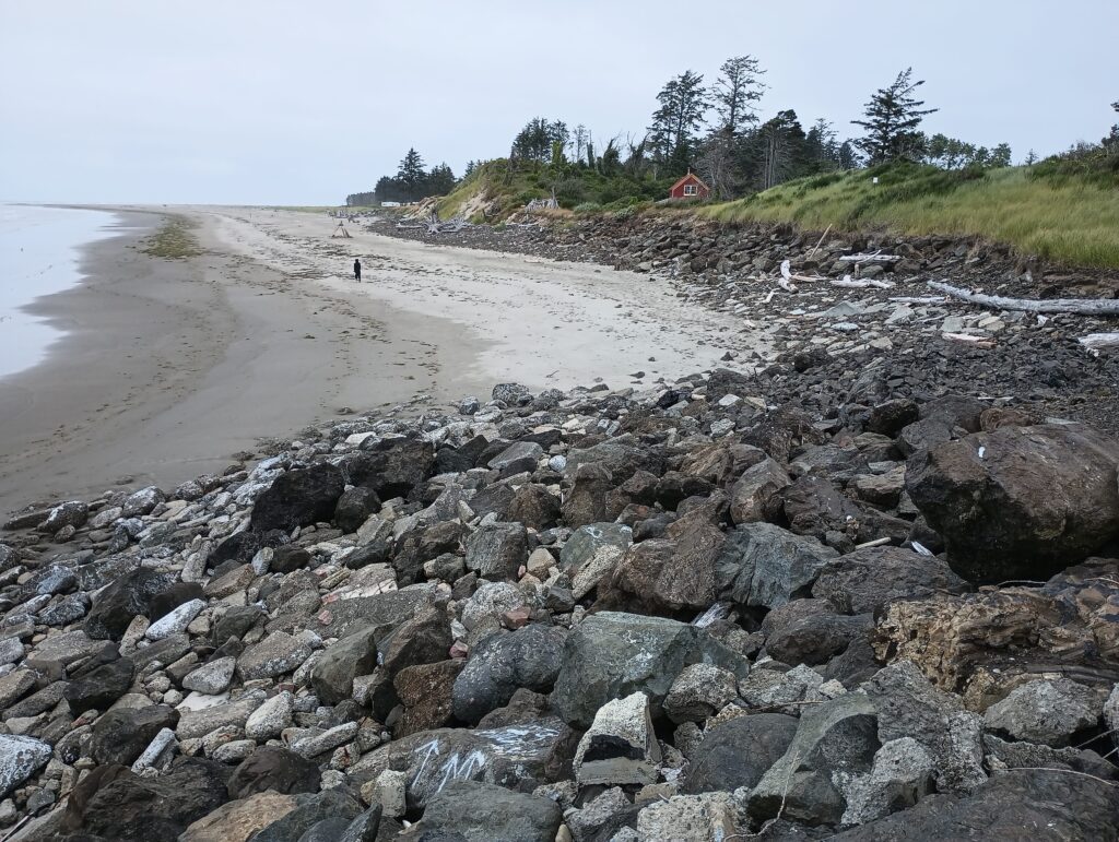 a rocky beach with a red house (MyCoast AI)