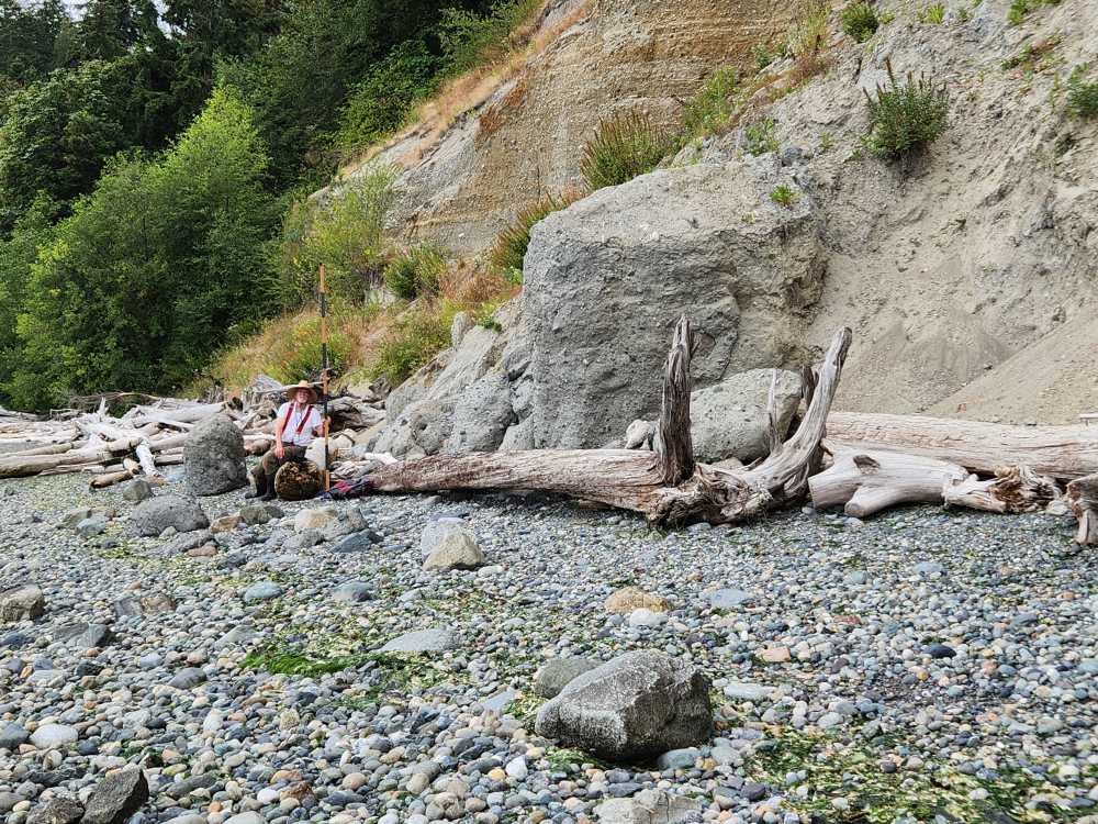 a person sitting on a log in a rocky river bed (MyCoast AI)