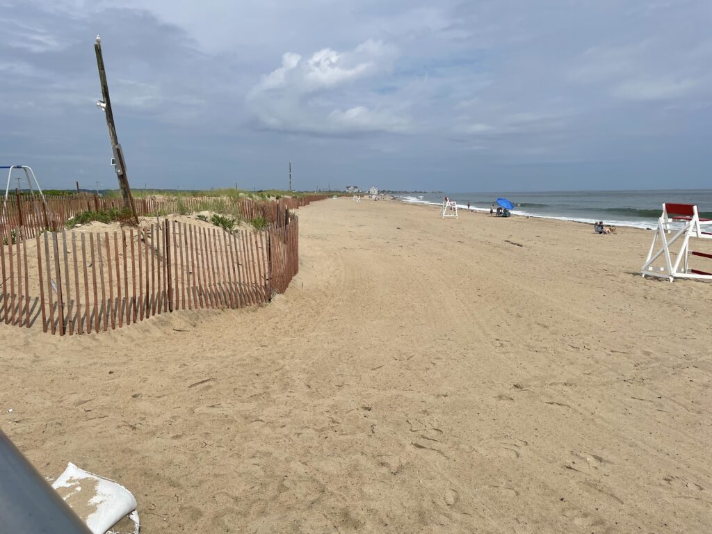 a sandy beach with a fence and a pole (MyCoast AI)