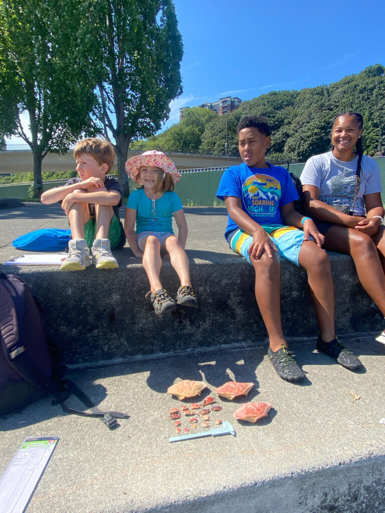 a group of people sitting on a bench by a lake (MyCoast AI)
