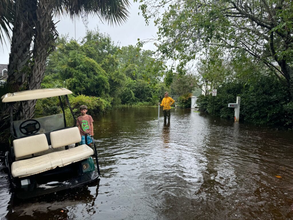 a person and a child walking in a flooded area (MyCoast AI)
