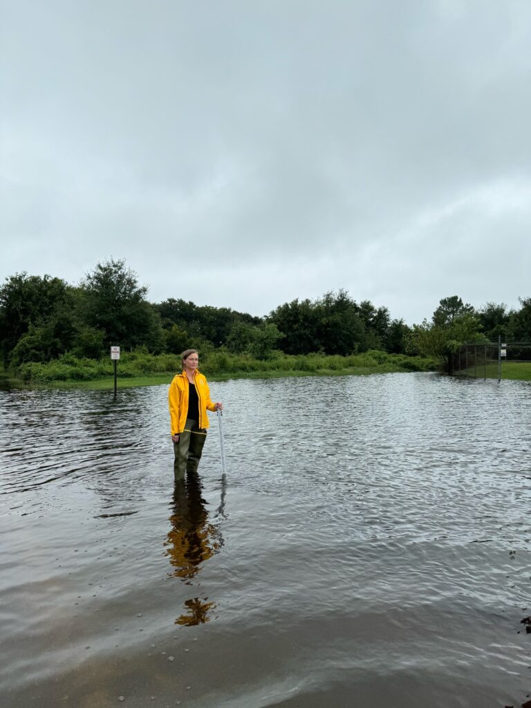 a man standing in a body of water holding a fishing pole (MyCoast AI)