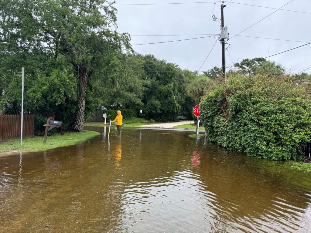 a flooded street with a person walking in the middle (MyCoast AI)