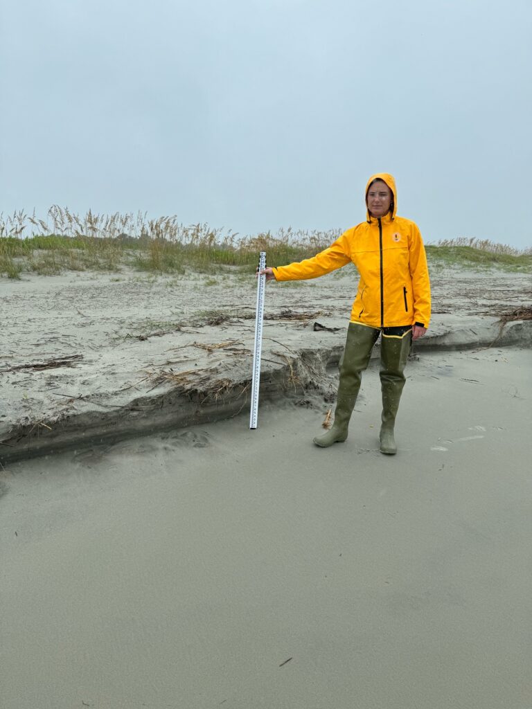a person standing in a body of water holding a pole (MyCoast AI)