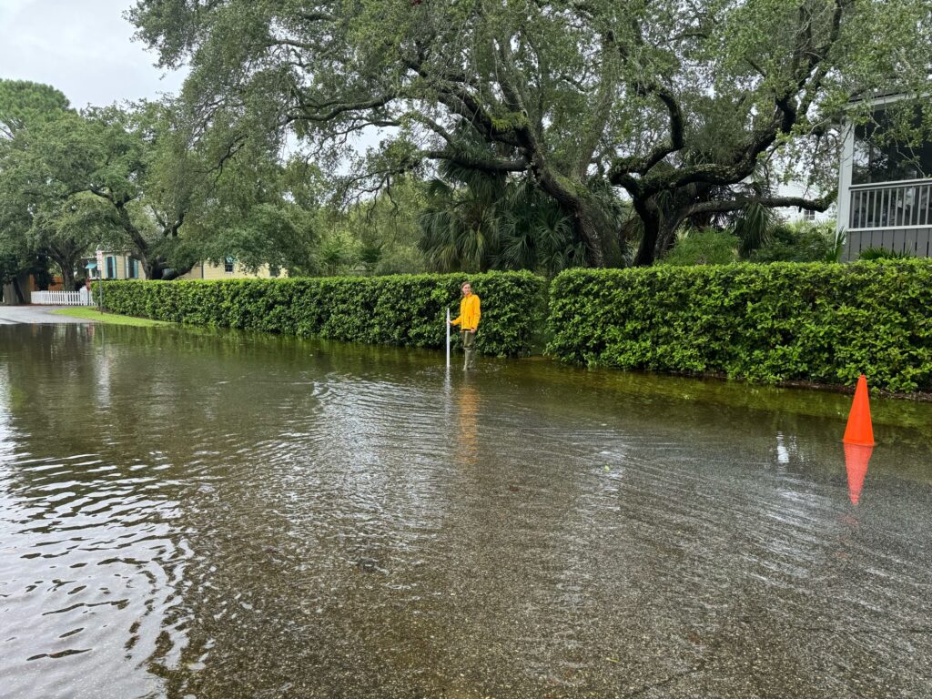 a person in a yellow shirt standing in a flooded area (MyCoast AI)