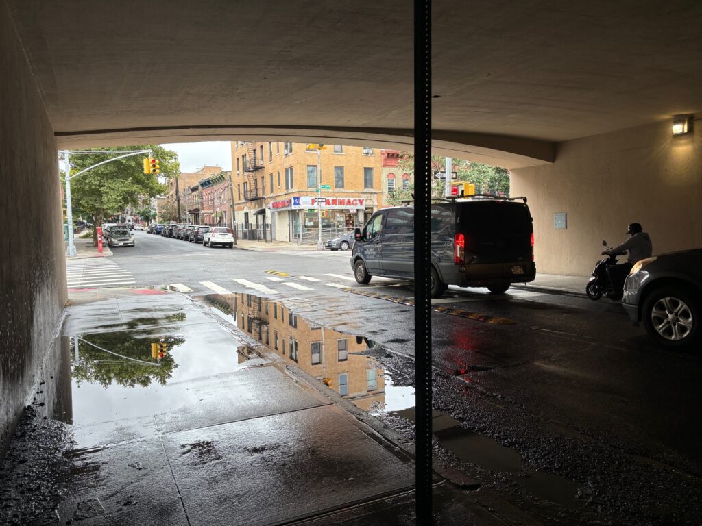 a wet street with cars and buildings (MyCoast AI)