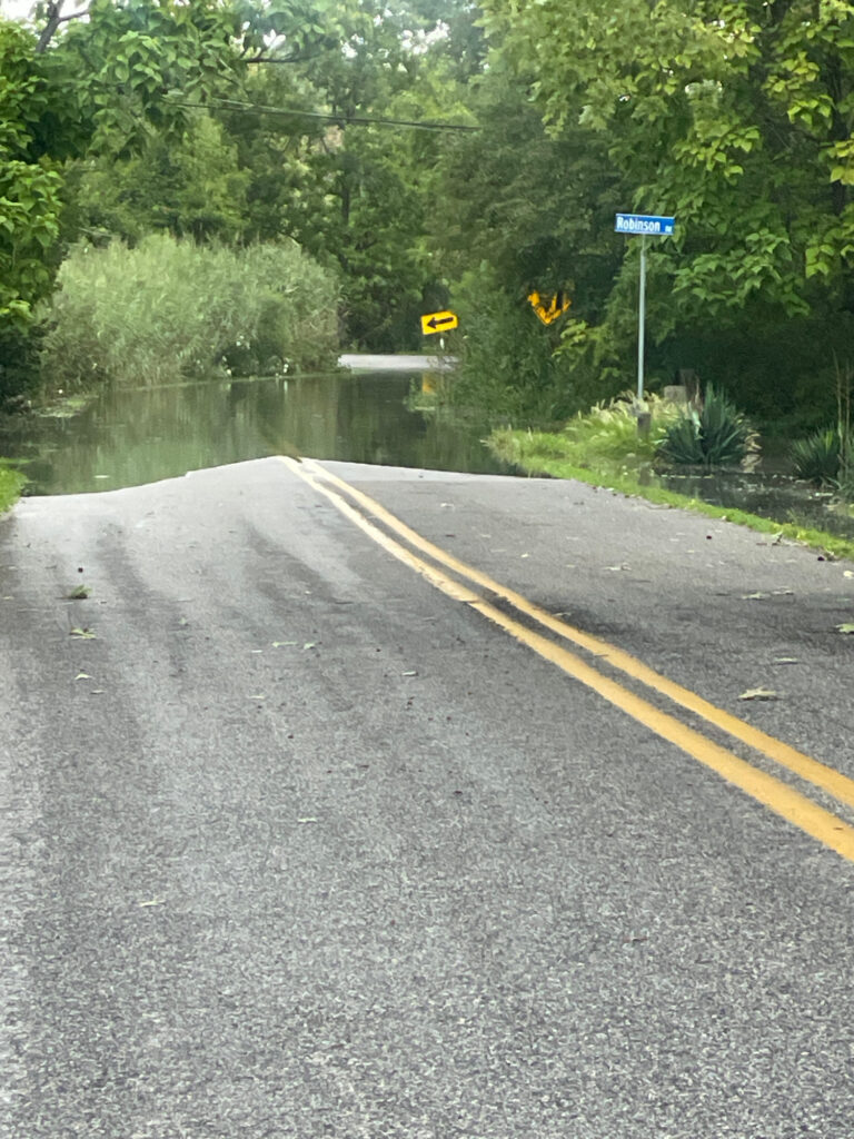 a flooded road with a sign (MyCoast AI)
