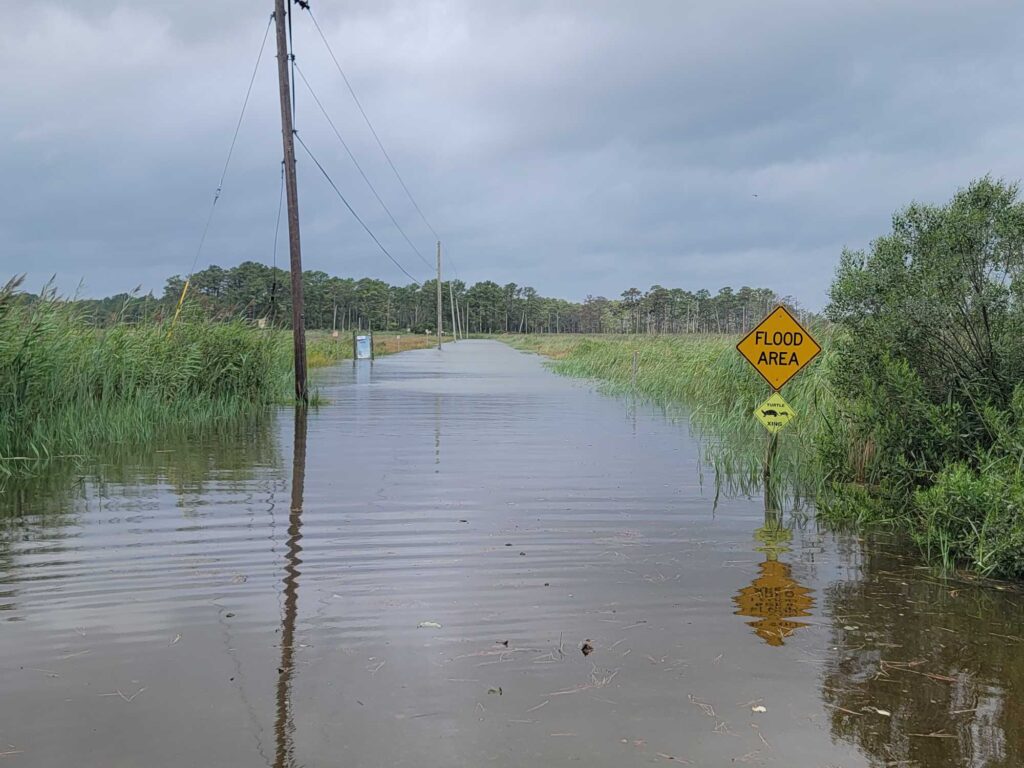 a flooded road with a yellow sign (MyCoast AI)