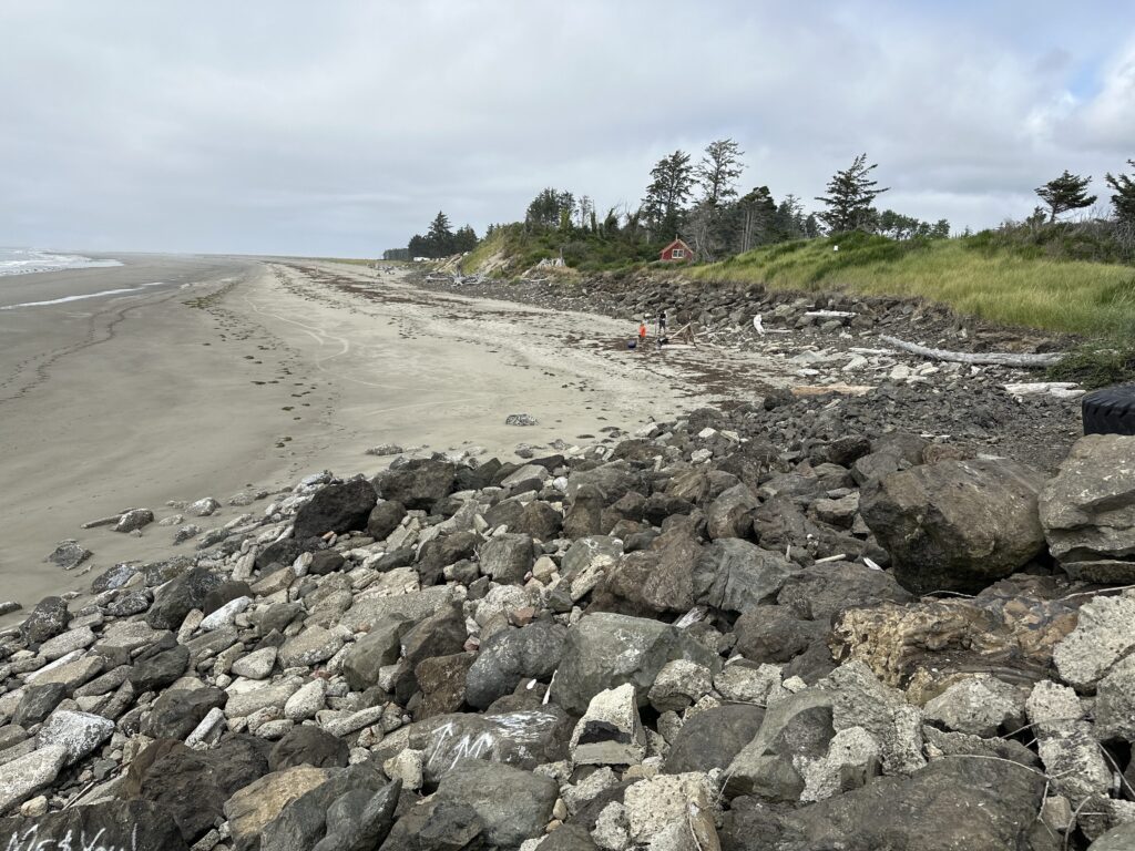 a rocky beach with a house in the background (MyCoast AI)