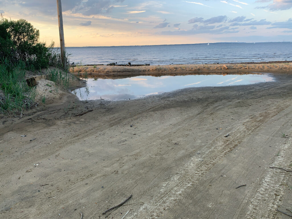 a sandy beach with water and a cloudy sky (MyCoast AI)