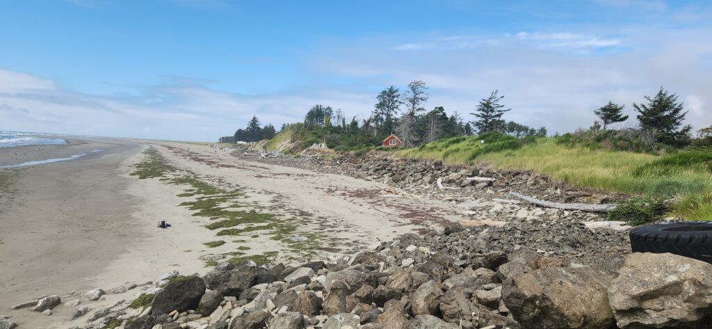a rocky beach with a house in the distance (MyCoast AI)
