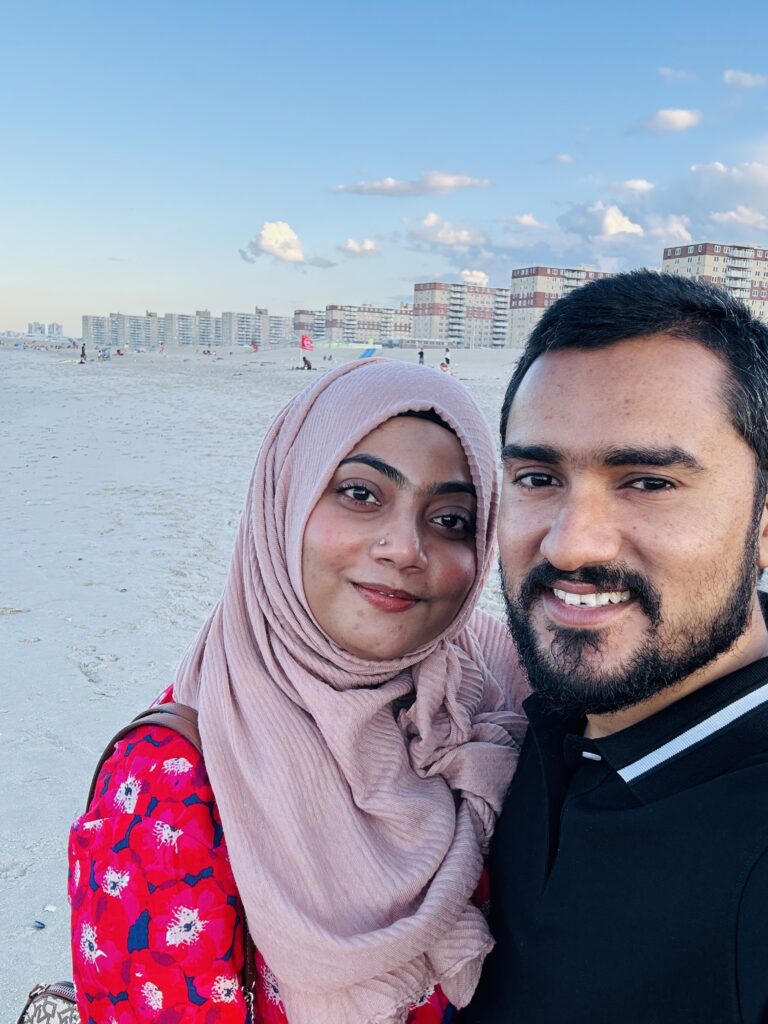 a man and woman taking a selfie on a beach (MyCoast AI)