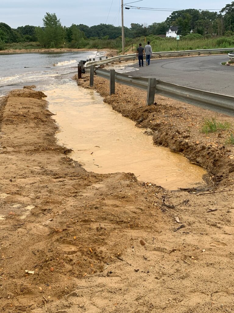 a road with a ditch and a person standing on the side (MyCoast AI)