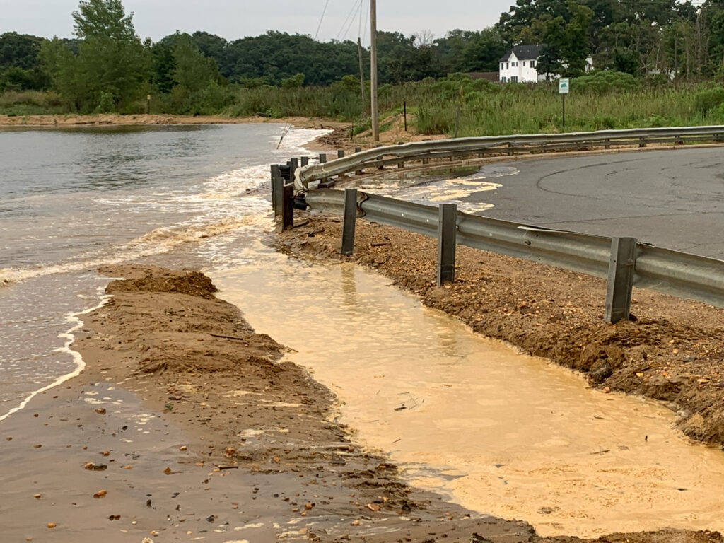 a flooded road with a wooden railing (MyCoast AI)
