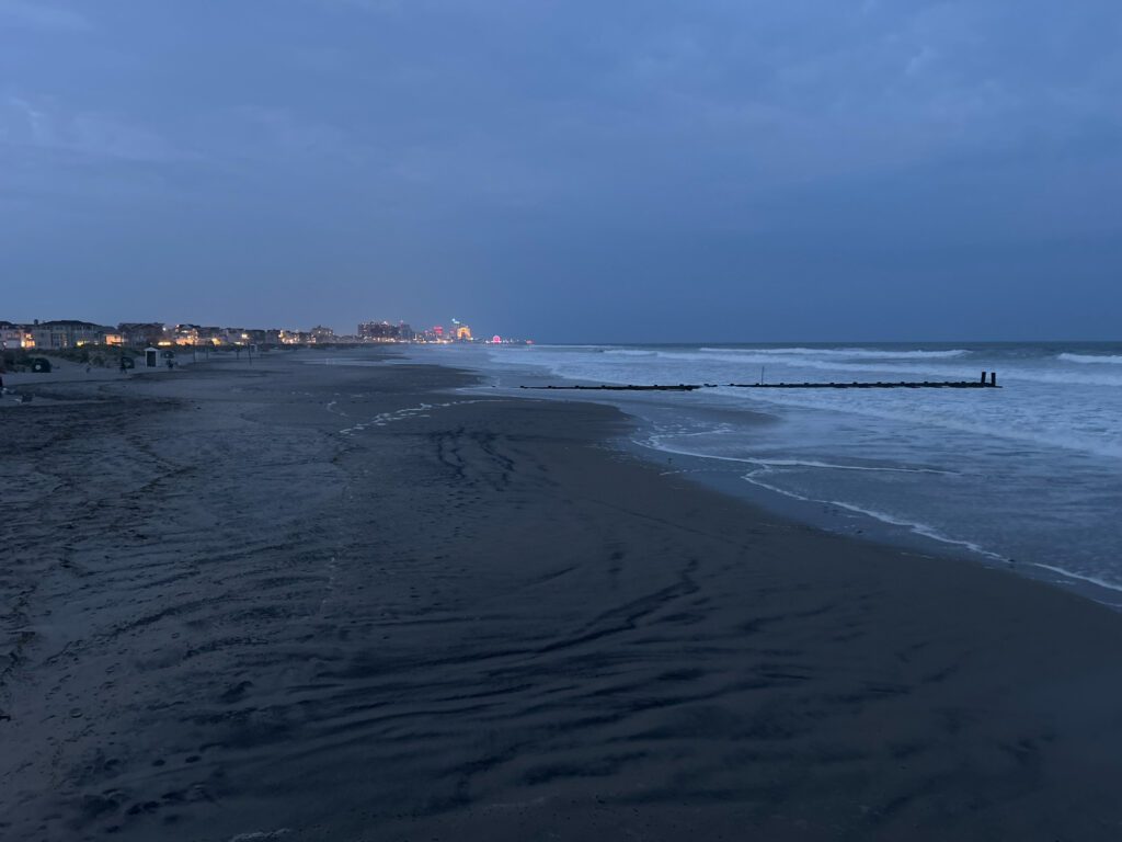 a beach with waves and buildings in the background (MyCoast AI)