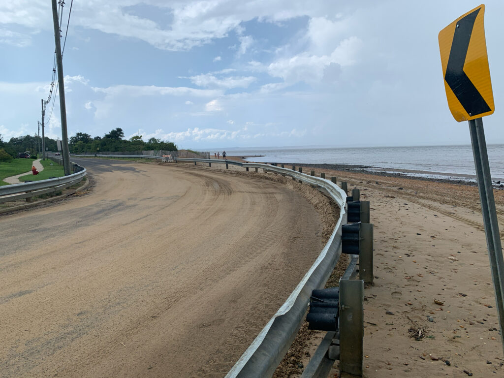 a road with a sign on it by a beach (MyCoast AI)