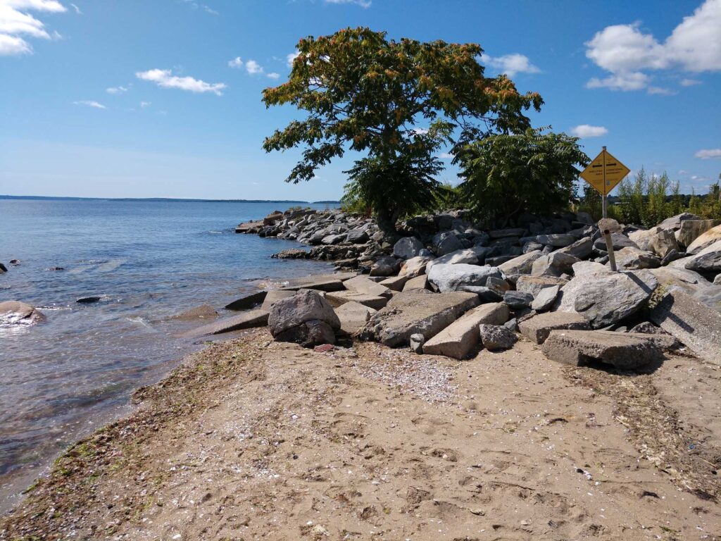 a rocky beach with a yellow sign (MyCoast AI)