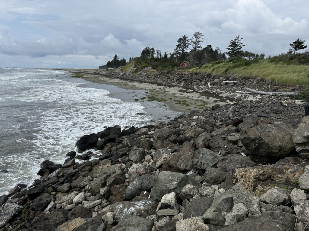 a rocky beach with a house in the background (MyCoast AI)