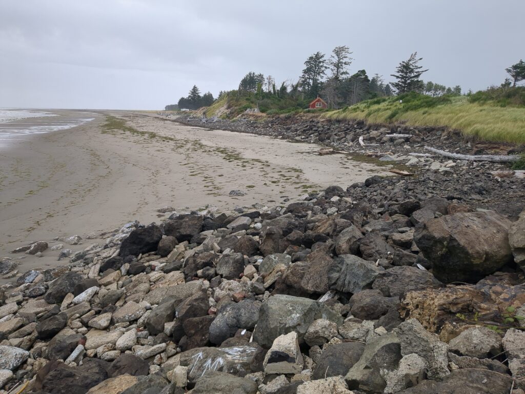 a rocky beach with a house in the distance (MyCoast AI)