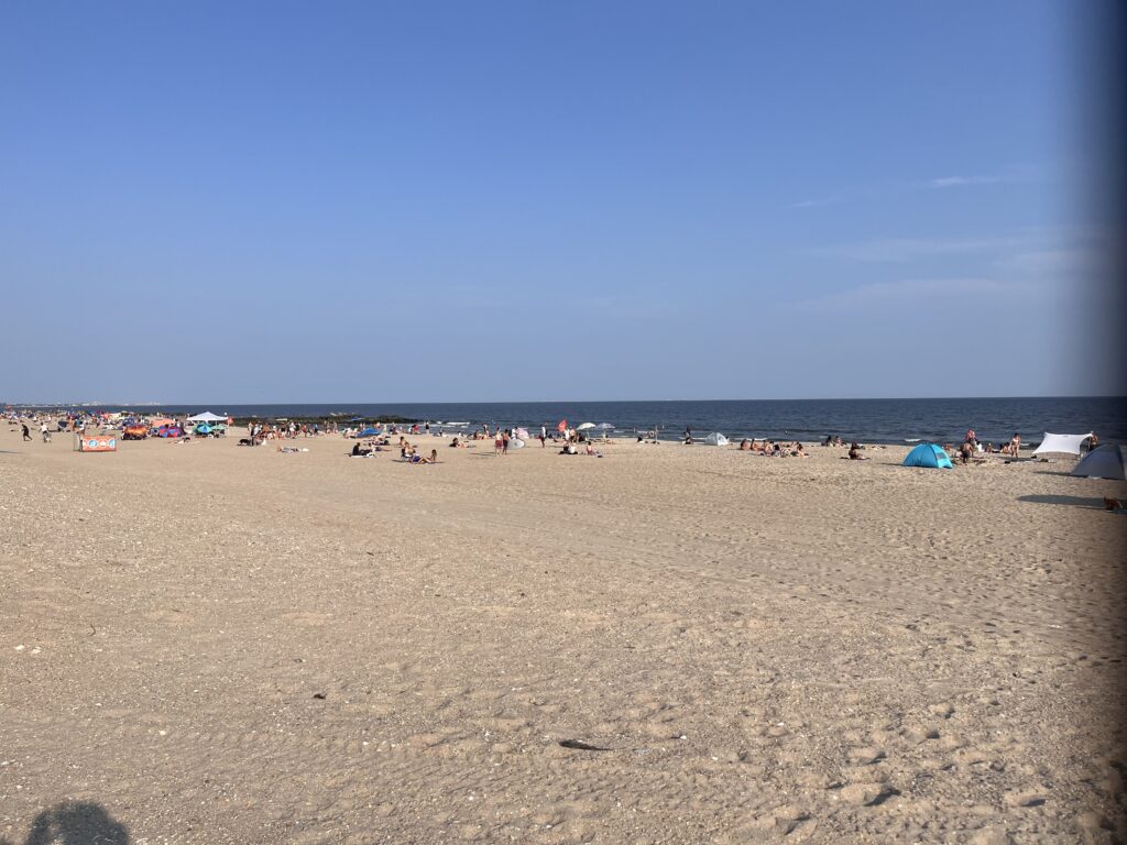a sandy beach with people and umbrellas (MyCoast AI)