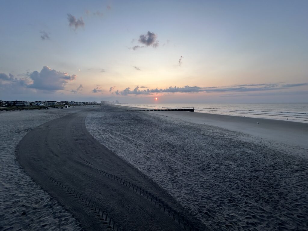 a beach with a body of water and a city in the distance (MyCoast AI)