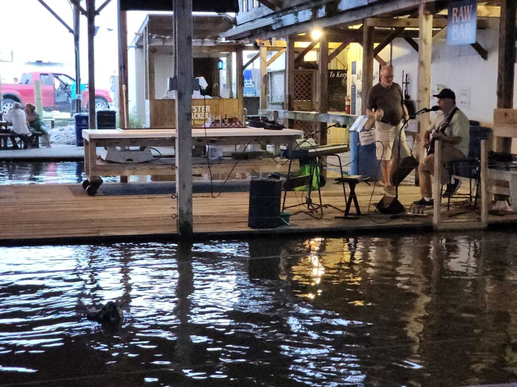 a couple of men standing on a dock by a body of water (MyCoast AI)